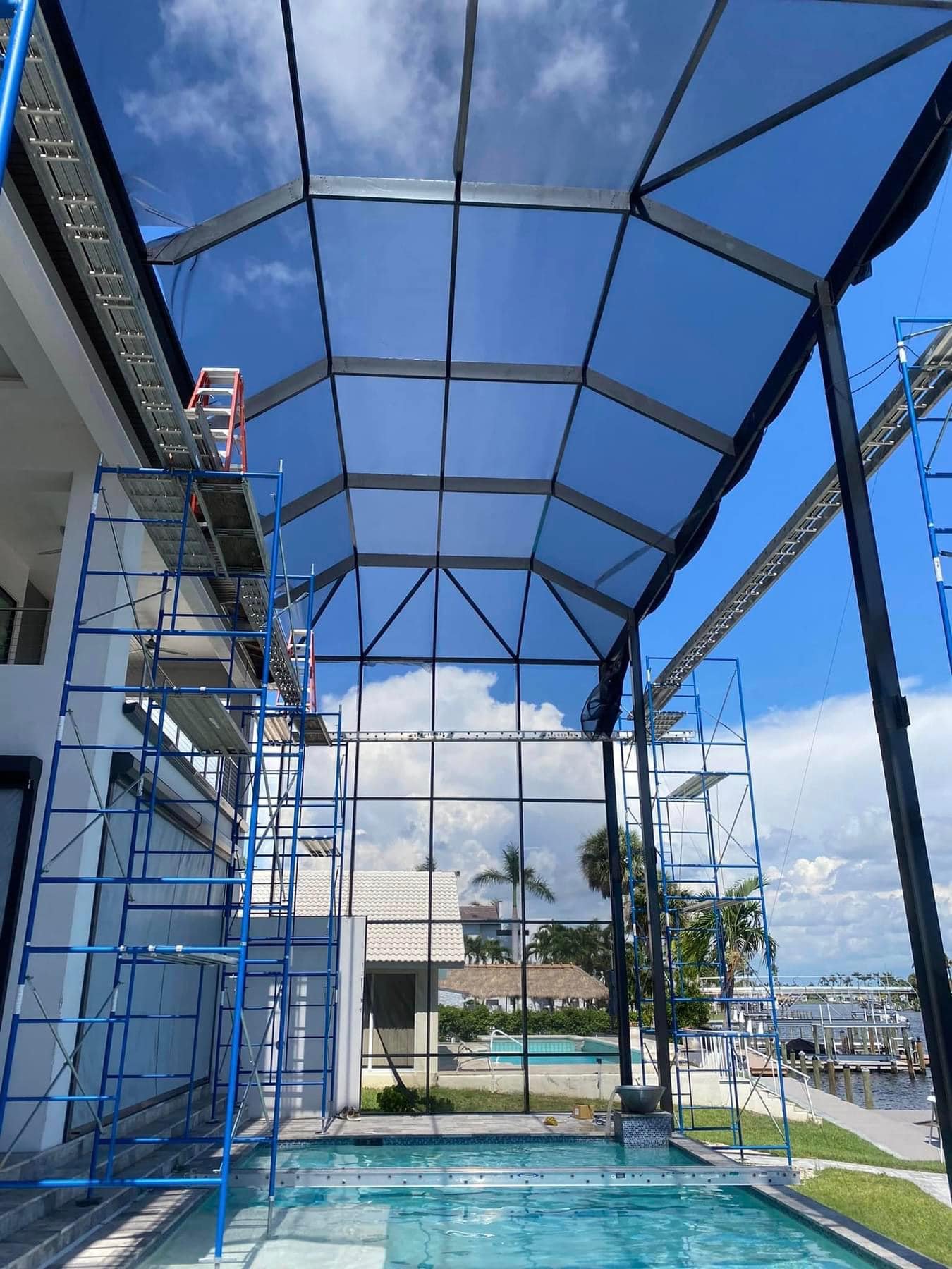 pool screen enclosure repair in Tallahassee, FL with scaffolding over residential pool